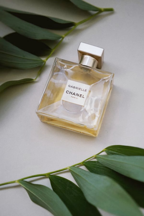 A bottle of parfume filled with golden liquid on a table.